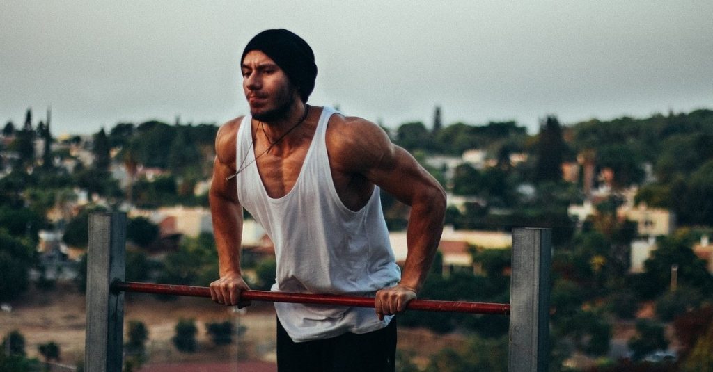 A man performing a chest exercise on a bar