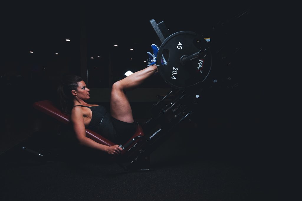 A woman working out her legs in a leg press machine