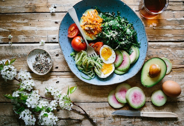 A plate filled with eggs, coal, tomatoes, and avocado is an example plate of foods for a fat-free diet.