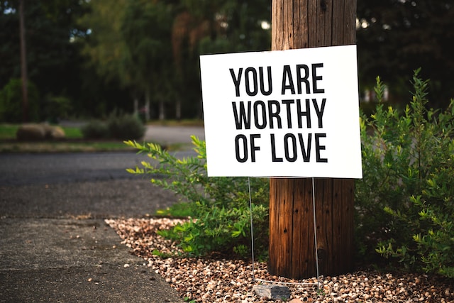 A sign with a positive affirmation written on it the text states the following "you are worthy of love".